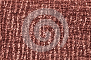 Dark brown fluffy background of soft, fleecy cloth. Texture of plush furry textile, closeup.