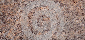 Dark brown granite with light inclusions, the texture of a natural polished stone close-up