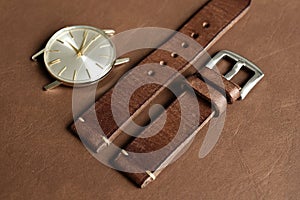 Dark brown leather watch strap with stainless buckle on leather background, Craft and handmade watch bracelet