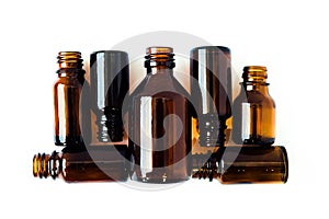 Dark brown phials on white background. Small empty bottles