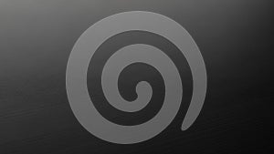 Dark brushed metal surface with subtle linear texture and soft light gradient