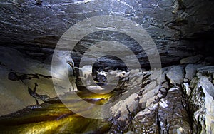 Dark cave with a stream flowing through it