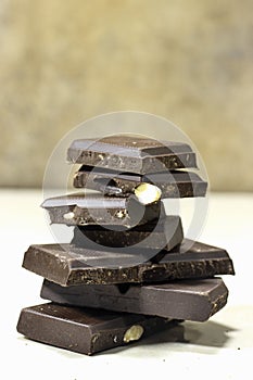 Dark chocolate almond stack, chocolate bars and block on marble background