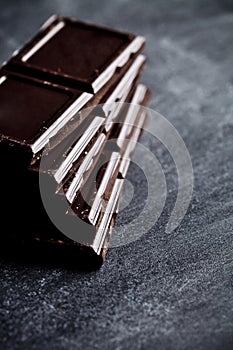 Dark chocolate bar pieces closeup. Sweet food photo concept