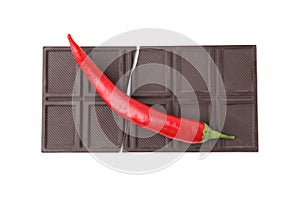 Dark chocolate bar with red hot chili pepper isolated on white, top view
