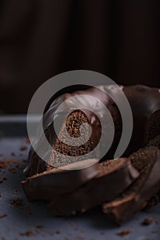 Dark chocolate cake covered with icing covered on a dark background. Selective focus.