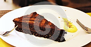 Chocolate cake dessert on a white plate with forks to share between two people