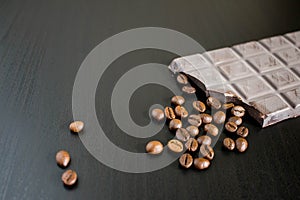 Dark chocolate and coffee beans on old wooden table