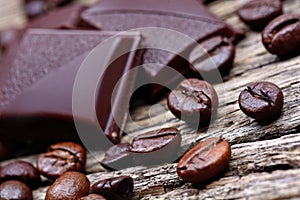 Dark chocolate with coffee beans on wooden table