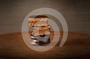 Dark chocolate and dulce de leche alfajores on a wooden table. Argentinian candy. Traditional argentinian food