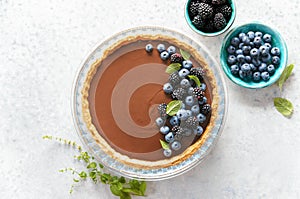 Dark chocolate mousse tart decorated with fresh blueberries and mint