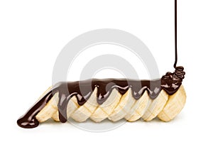 Dark chocolate is poured on the banana slices