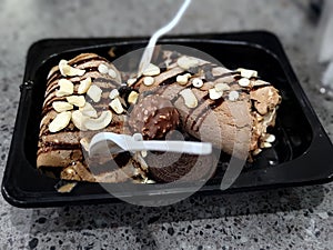 Dark chocolate roll in black box with cashew topping