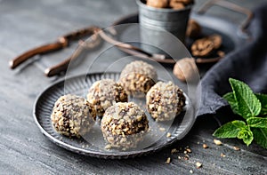 Dark chocolate truffle coated in chopped and toasted walnuts on a plate