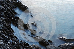 Dark cliffs, long exposure blue water