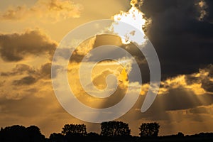 Dark clouds back-lit by rising sun