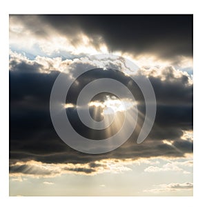 Dark clouds dominate the sky, with sunlight piercing through, creating dramatic