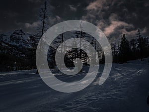 Dark clouds obscure a snowy mountain landscape