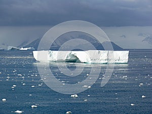 Dark Clouds over arched iceberg Antarctica