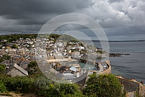 Dark clouds over Mousehole Harbour in Cornwall UK