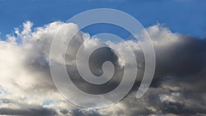 Dark clouds with silver edges,in a blue sky.