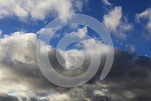 Dark clouds with silver edges,in a blue sky.