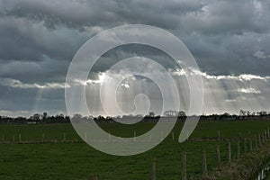 Dark clouds with silver lining over grassland