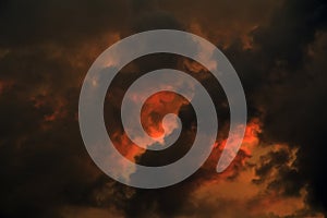 Dark clouds at sunset with dramatic red and black clouds.