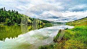 Dark Clouds and surrounding Mountains reflecting on the smooth water surface of Trapp Lake