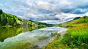 Dark Clouds and surrounding Mountains reflecting on the smooth water surface of Trapp Lake