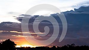 Dark cloudy sky background over the sunset in the evening sky in the countryside of Thailand.