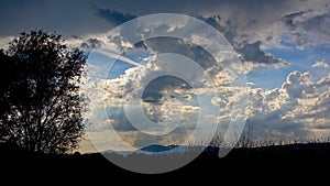 Dark cloudy sky in the evening light over silhouette of Romanian mountains