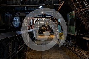 Dark coal mine tunnel with minimal light, showing deep stope and active coal extraction.