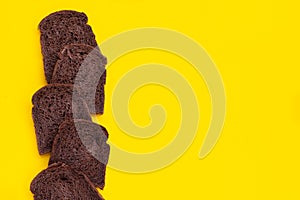 Dark cocoa bread on yellow background