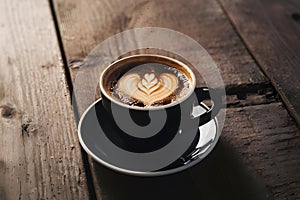 Dark coffee cup sits on wooden table, exuding fresh caffeine