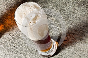 Dark cold beer with frothy photo