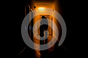 Dark corridor with cabinet doors and lights with silhouette of spooky horror man standing with different poses.