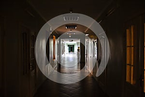 A Dark corridor in the hospital. A long terrible corridor with light from the windows. Scary way