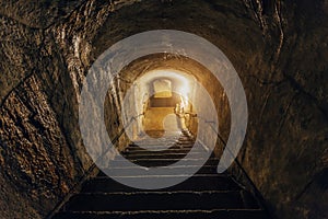 Dark corridor of old abandoned underground Soviet military bunker. Staircase goes down