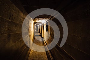 Dark corridor of old underground Soviet military bunker under artillery fortification.