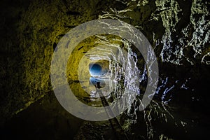 Dark creepy dirty flooded abandoned mine tunnel