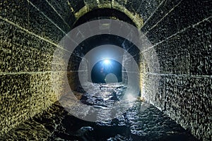 Dark and creepy old historical vaulted flooded underground drainage tunnel
