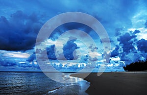 Dark dangerous tropical storm clouds rolling in sky over ocean coastal beach