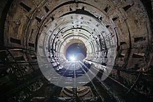 Dark dirty abandoned subway tunnel with rusty railway