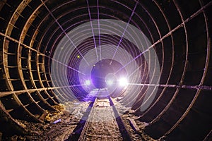 Dark dirty abandoned subway tunnel with rusty railway