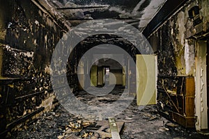 Dark dirty corridor in soot and ash, burnt-out abandoned building, fire consequences concept