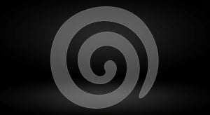 A dark, empty background with a gradient of black shades, creating a subtle spotlight