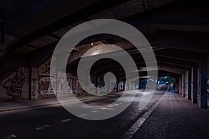 Dark empty dirty grunge underground concrete tunel with a road during mystic night with blue street