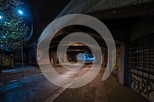 Dark empty dirty grunge underground concrete tunel with a road during mystic night with blue street