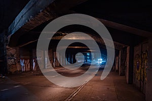 Dark empty dirty grunge underground concrete tunel with a road during mystic night with blue street